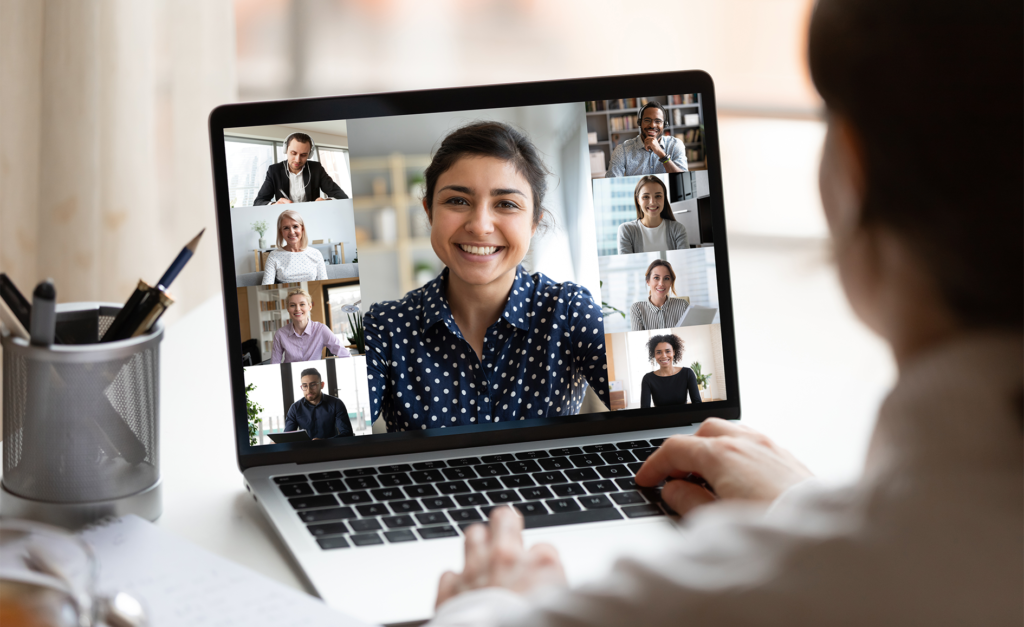 Woman sit at desk looking at computer screen where collage of diverse people webcam view