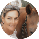 a smiling Sid Trudgett with her horse looks at the camera