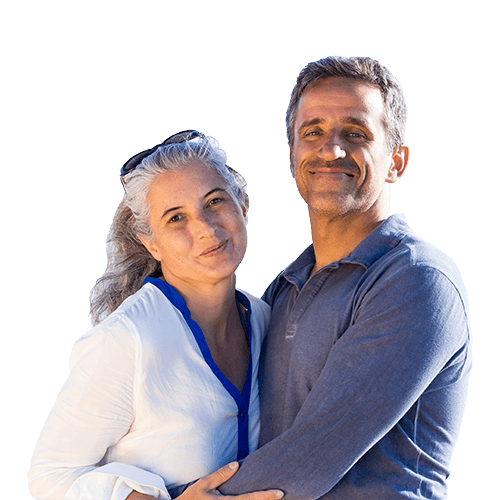 middle aged couple standing, smiling while hugging and looking at camera